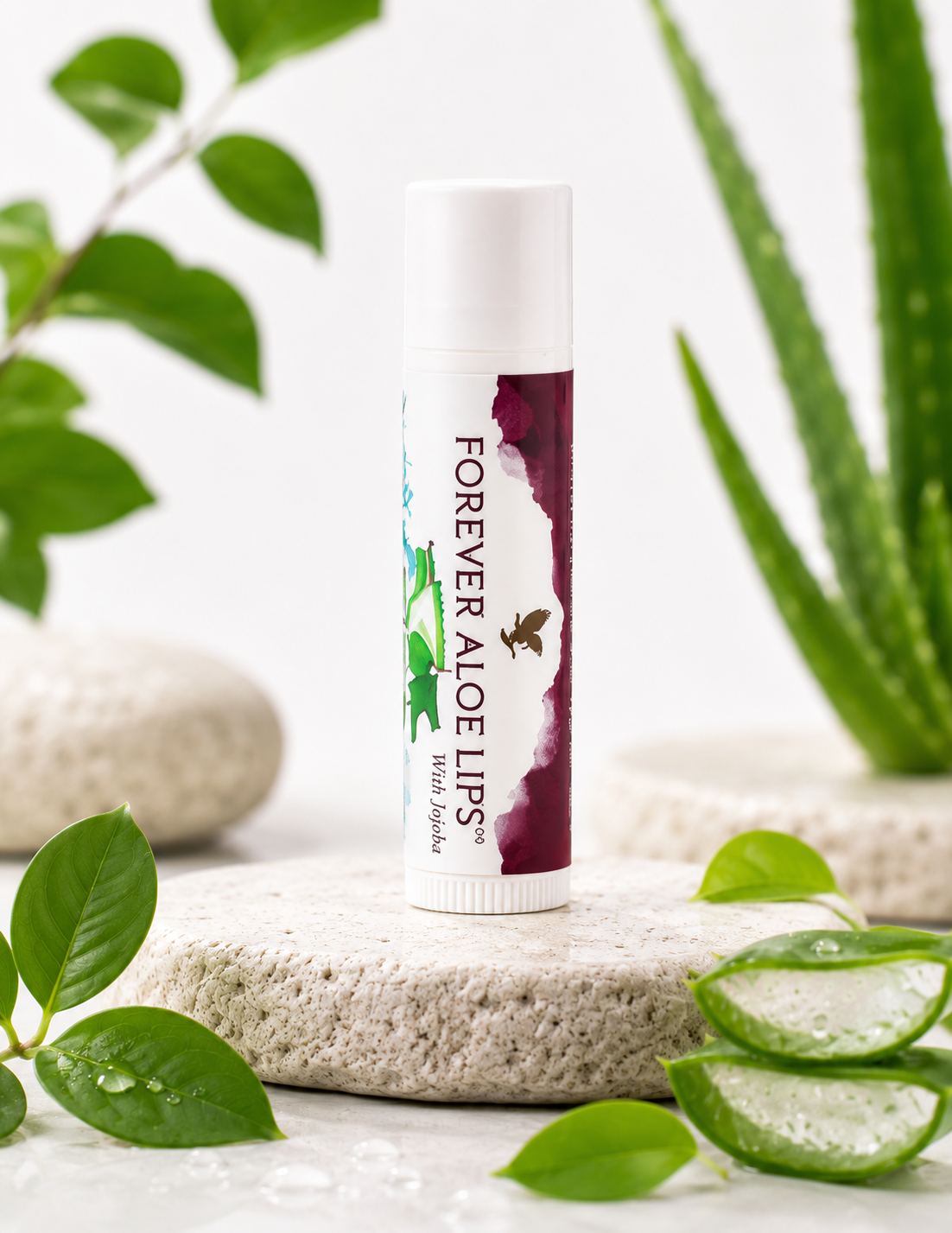 Forever Aloe Lips lip balm with jojoba on stone platform